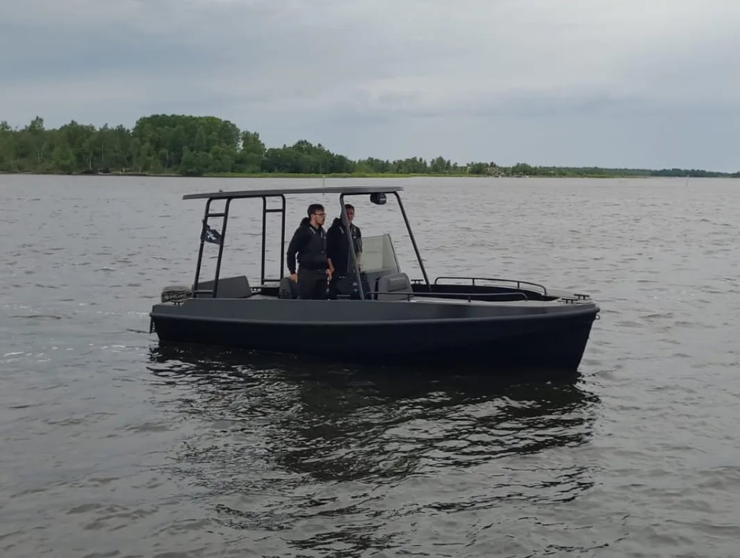 Un bote negro con dos personas en él.