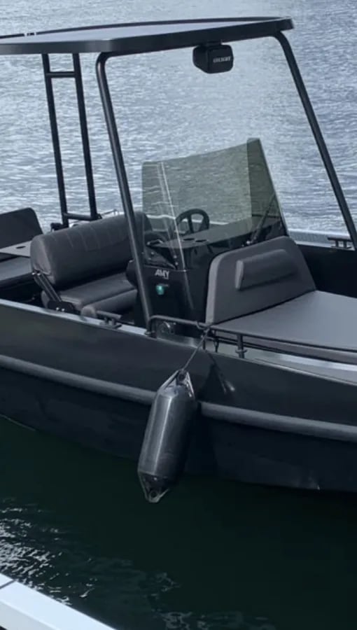 Un bote negro y gris con un parabrisas transparente.