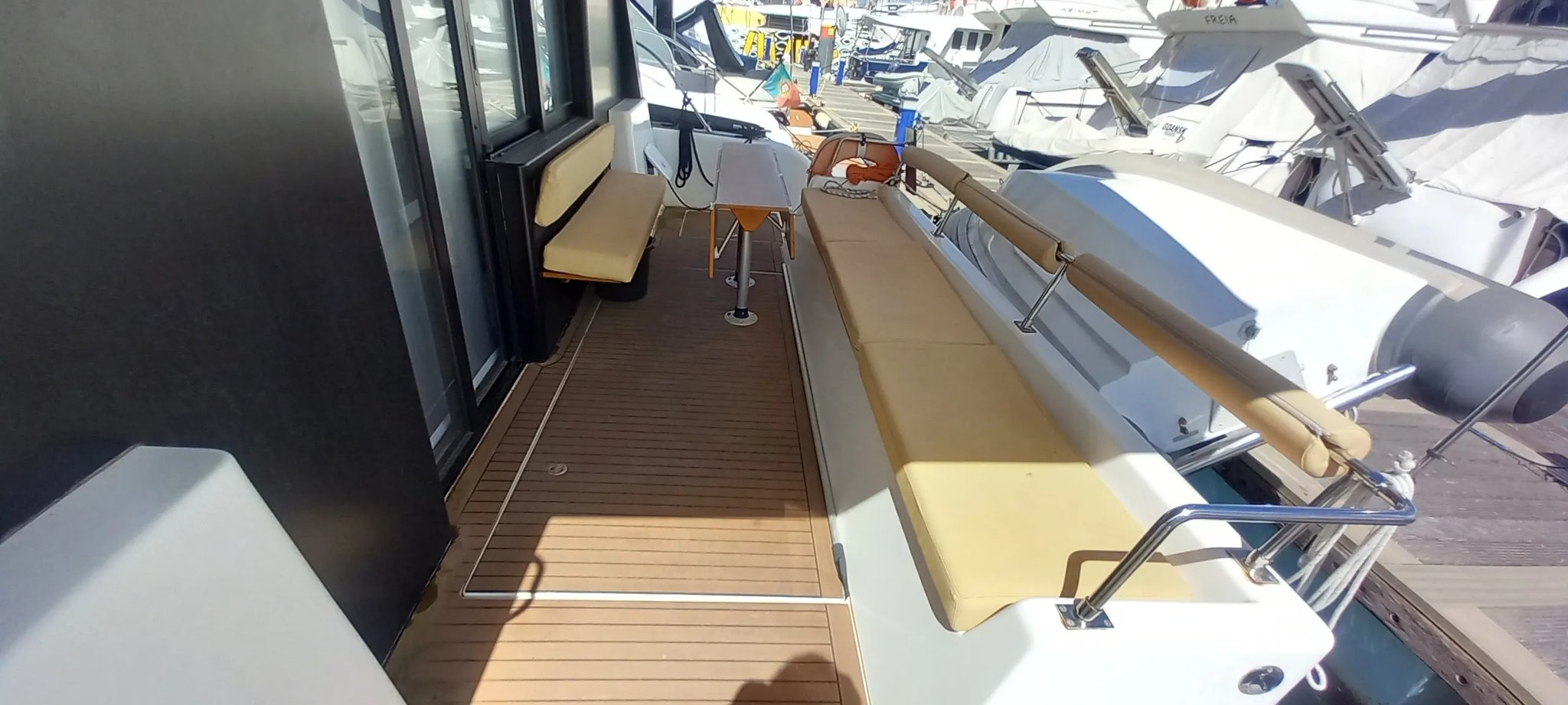 Un barco blanco con un banco marrón en la cubierta.