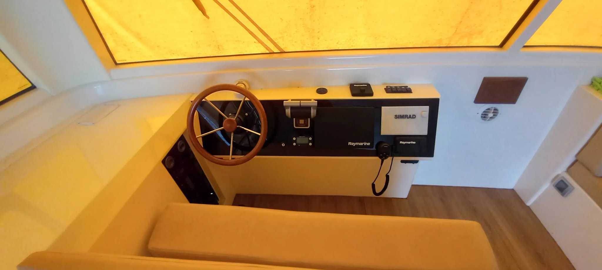 Un bote con un volante de madera y una caja negra en el tablero de instrumentos.