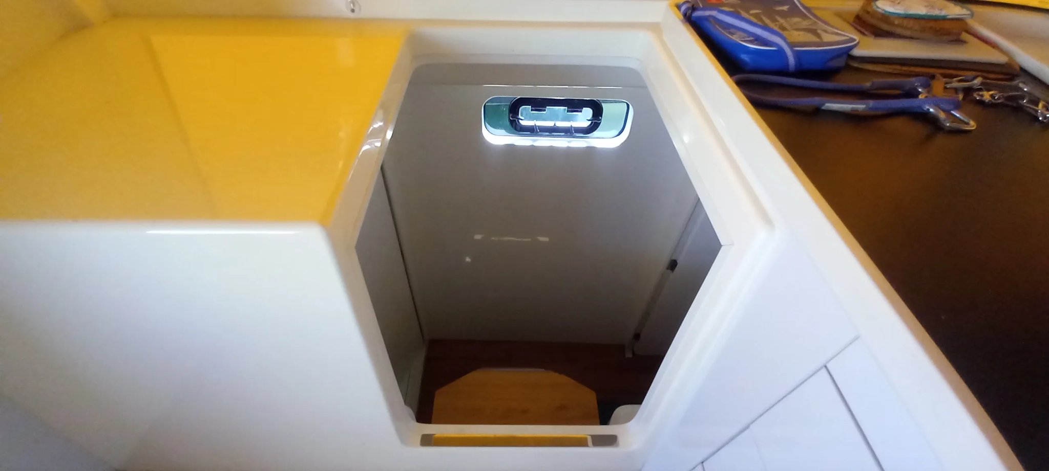 Un bote amarillo y blanco con una ventana en el lado.