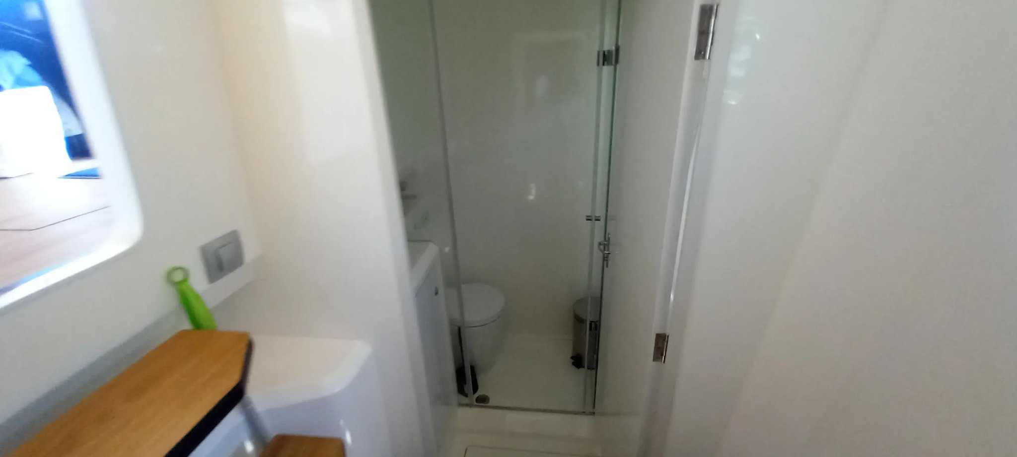 Un baño blanco con un inodoro y una ducha.