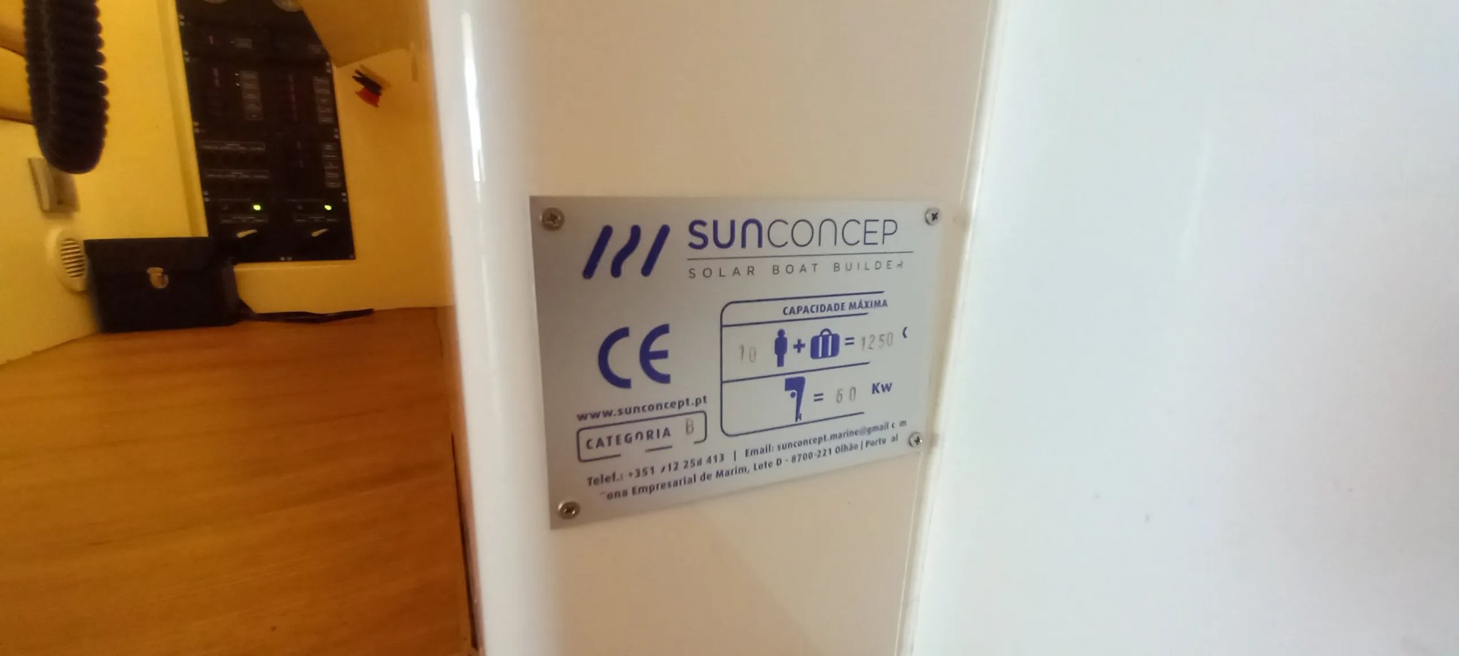 Un barco con energía solar con un letrero azul y blanco en el lado.