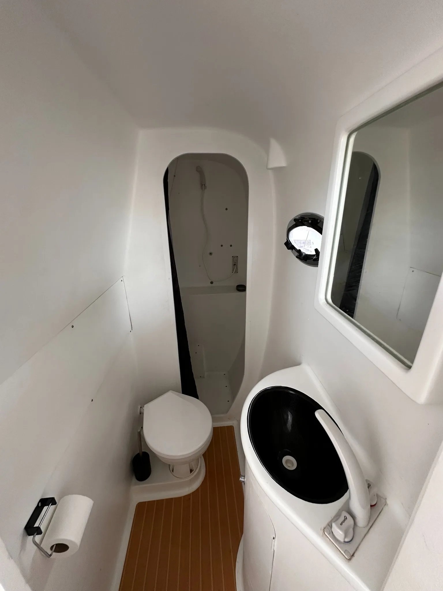 Bathroom aboard the Earthling E40 with a toilet, washbasin and separate shower area.