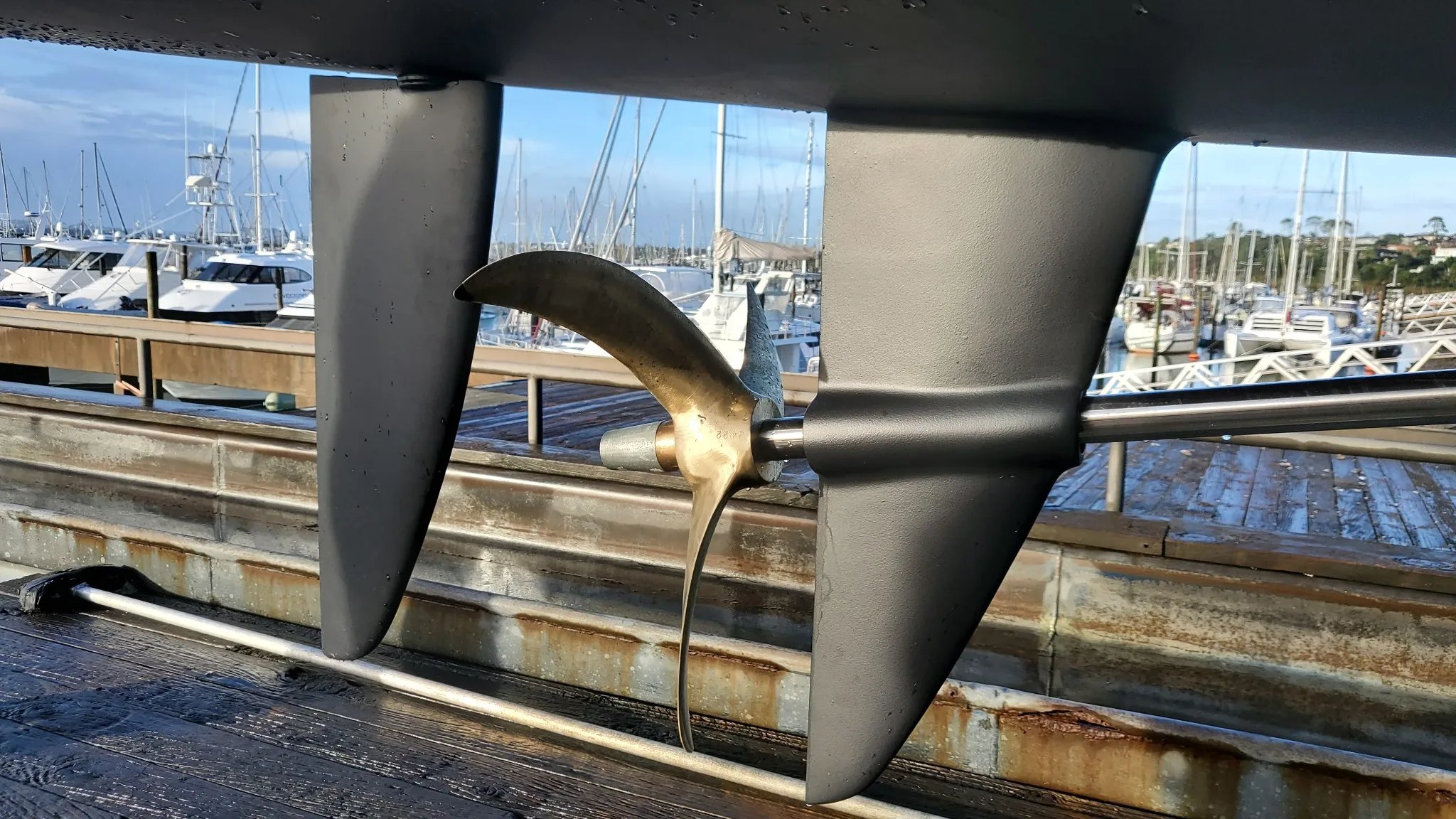 Propeller and rudder assembly of the Earthling E40 electric power catamaran viewed out of the water.