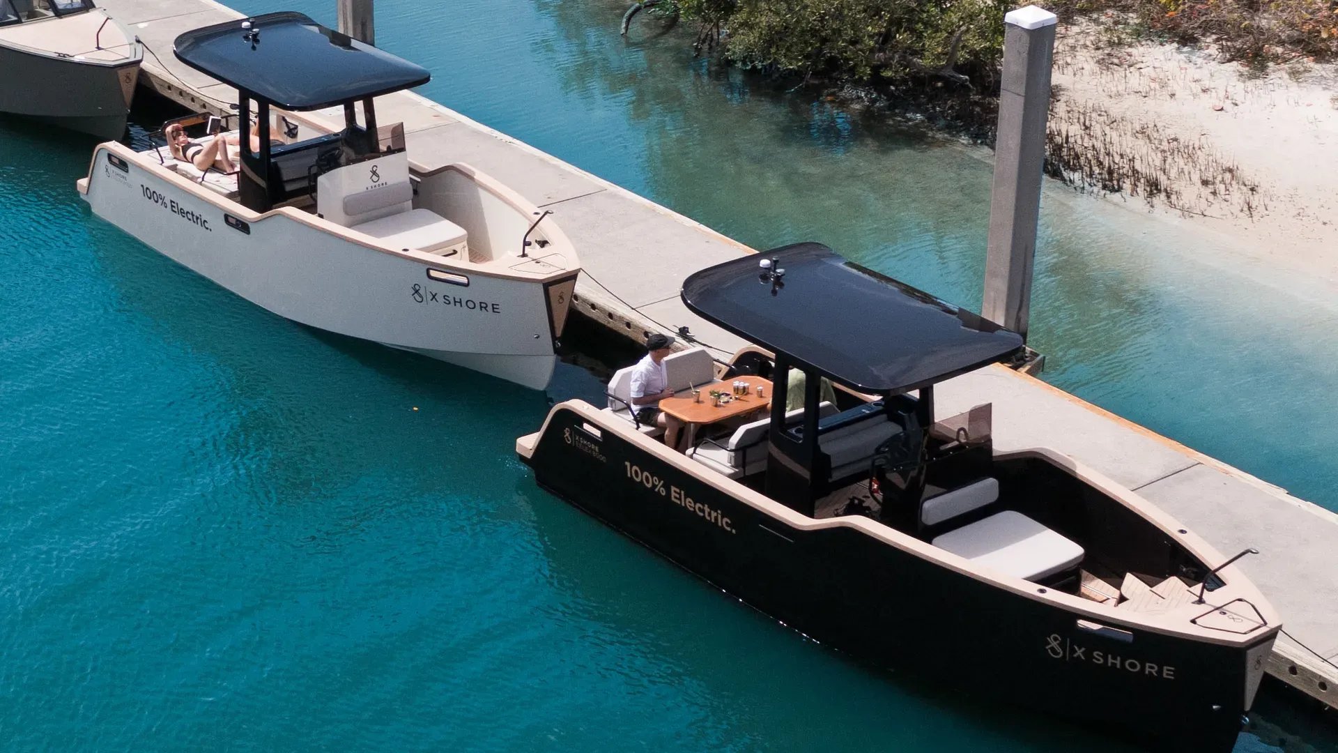 Two X Shore Eelex 8000 electric boats showing different modular deck configurations at a dock