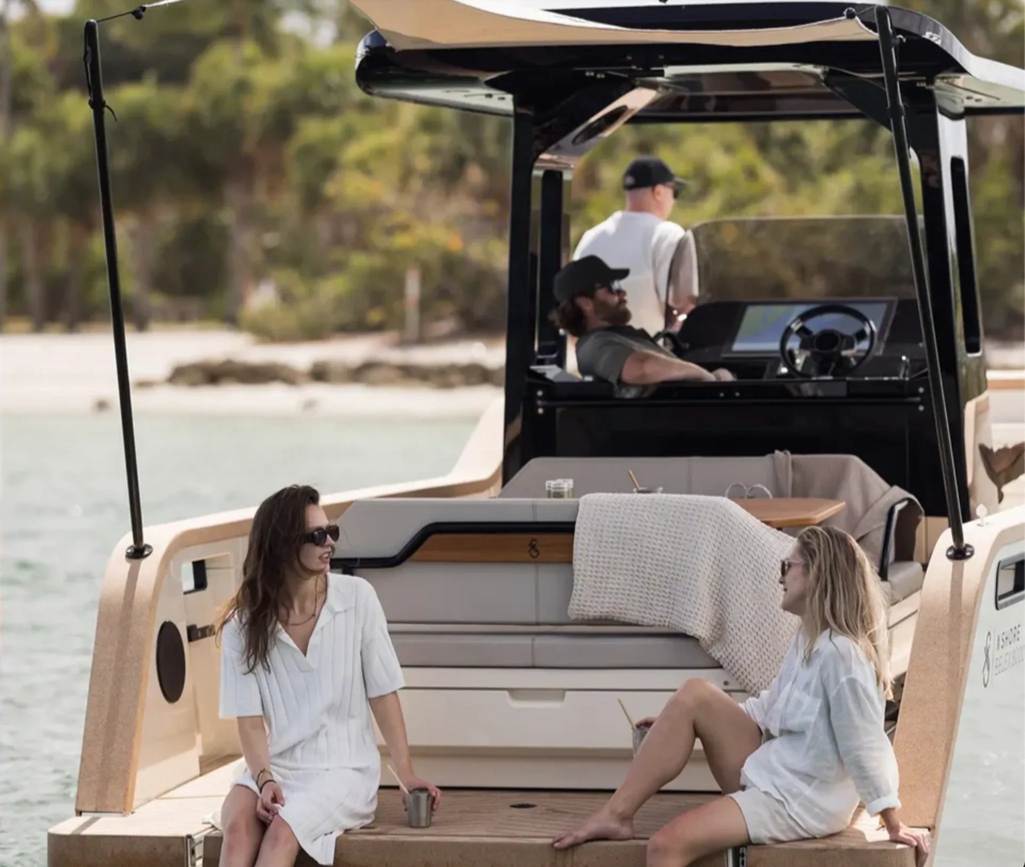 Aft social deck of the X Shore Eelex 8000 with passengers relaxing by the water