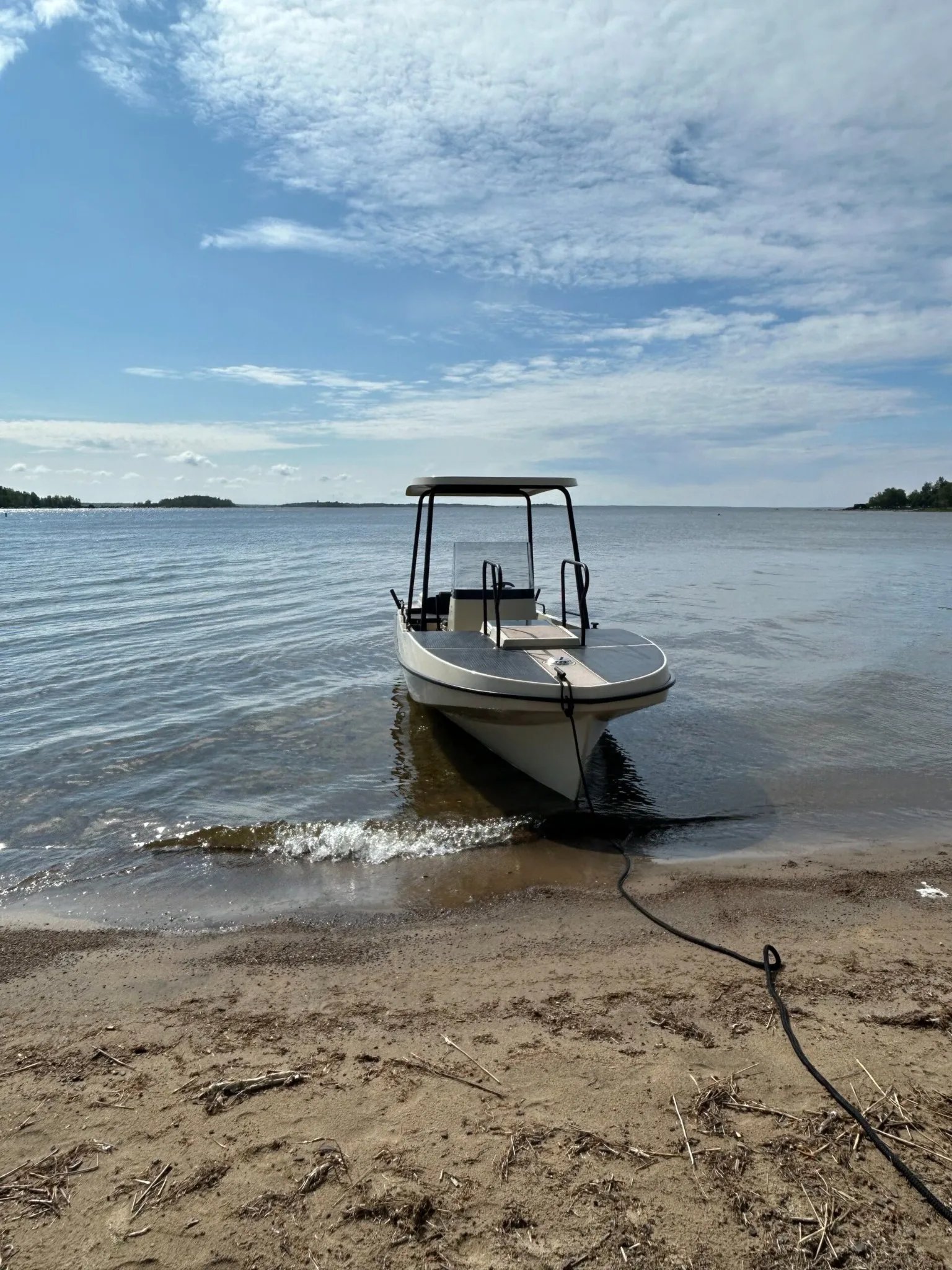 Front view of the Elvene Amber solar-electric boat showing the open bow deck and solar canopy.