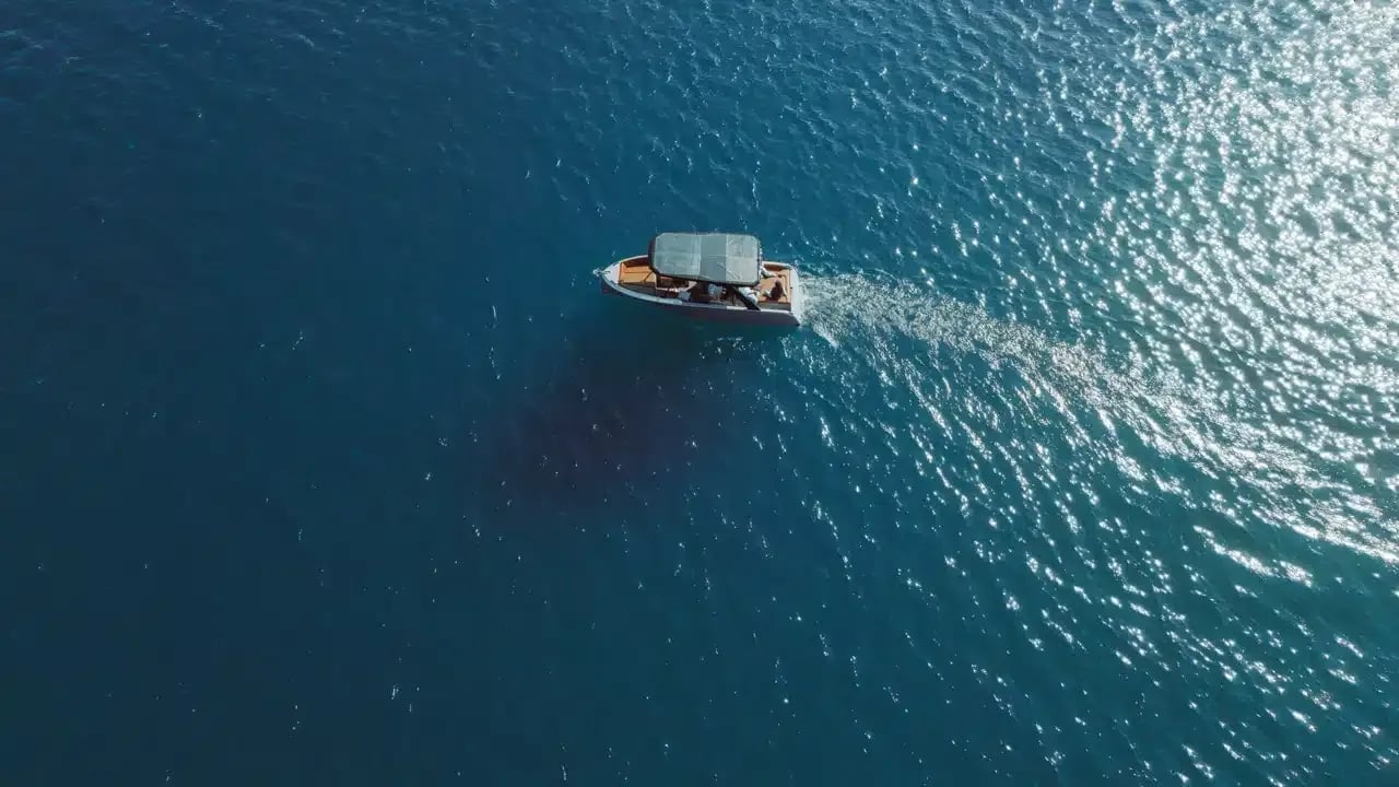 A boat with a canopy on top, floating on the water.