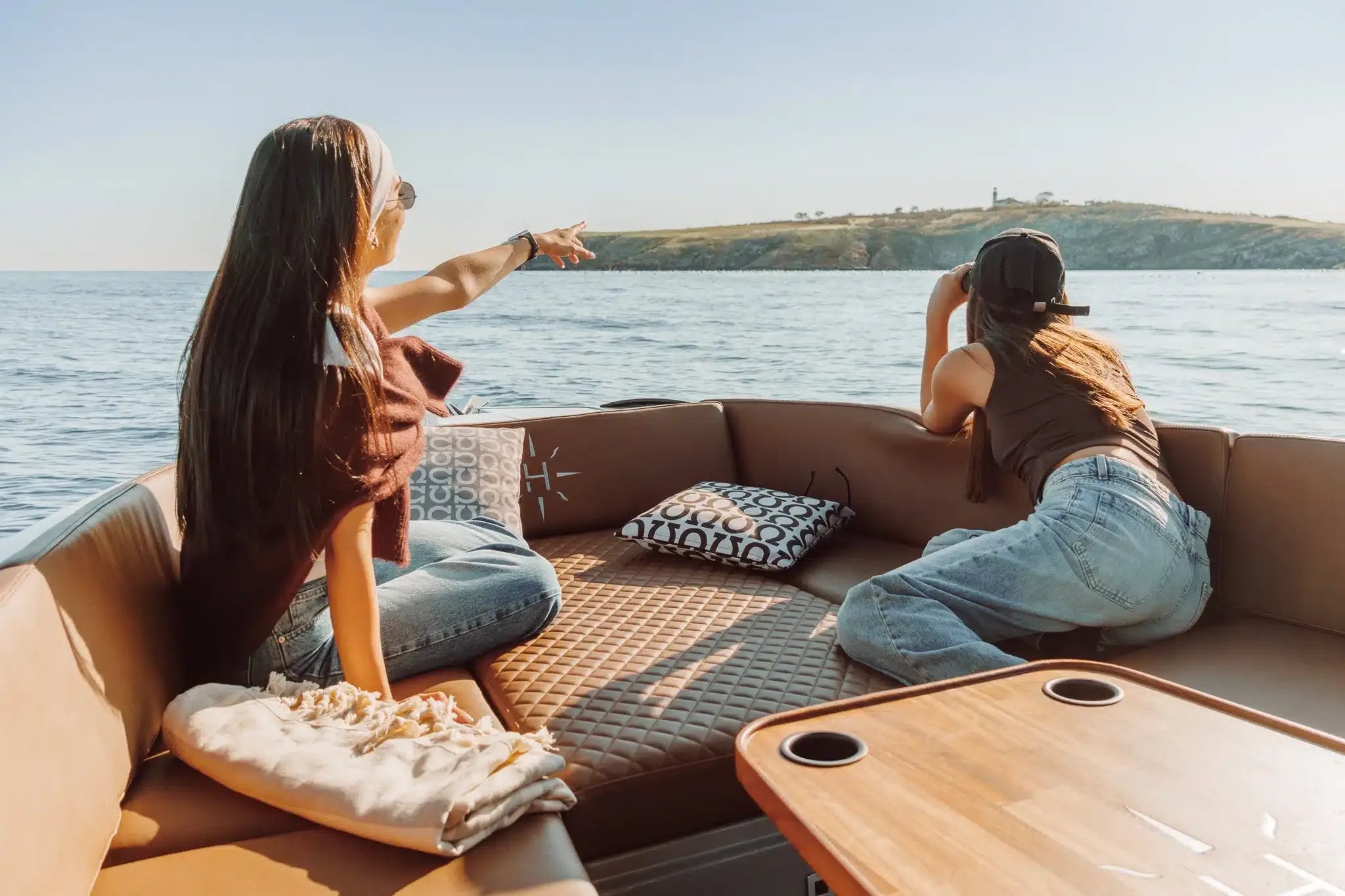 Two passengers relaxing in the lounge area of the Helios Omega electric boat.