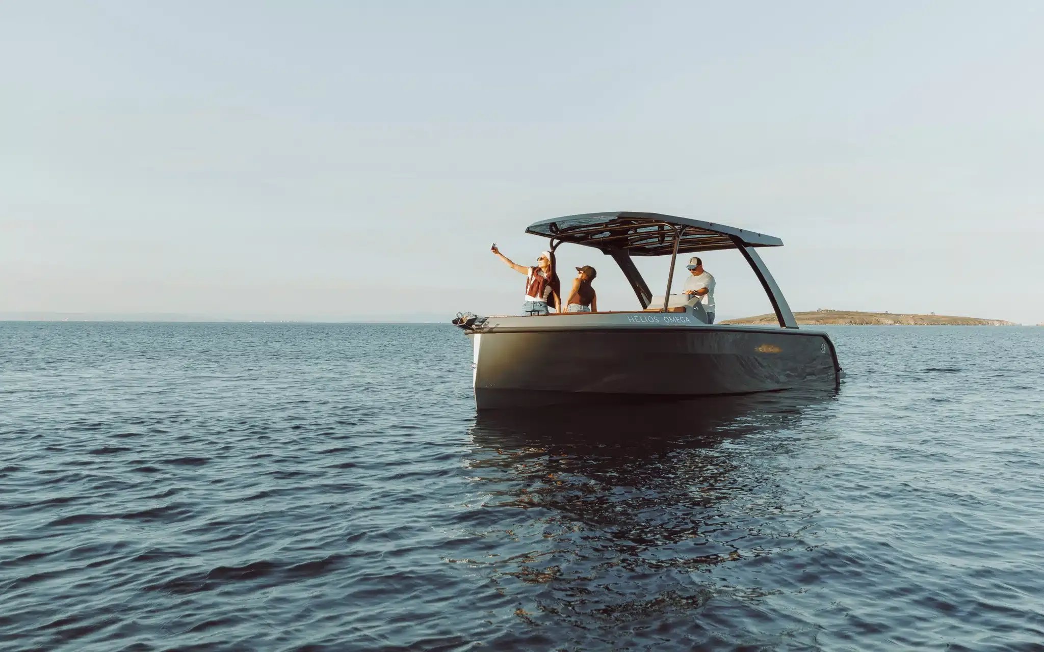 A black boat with a canopy on the water.