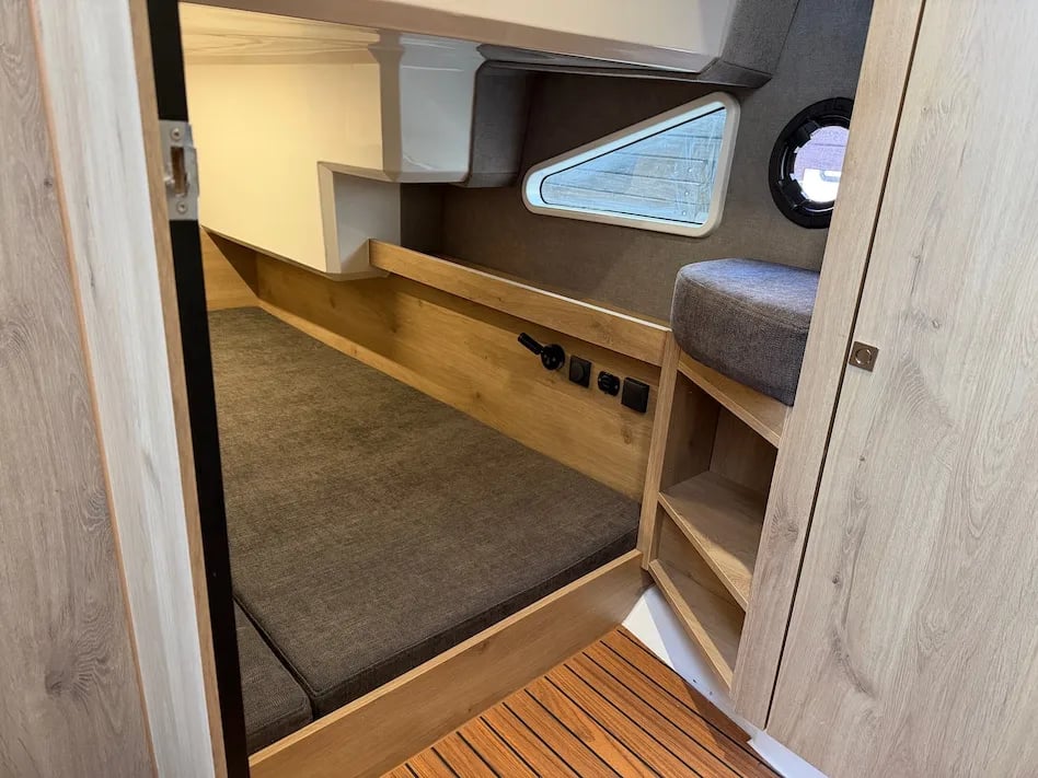 Cabin berth aboard the Lamdo eLY30+ with side windows, shelving and wood-finish details.