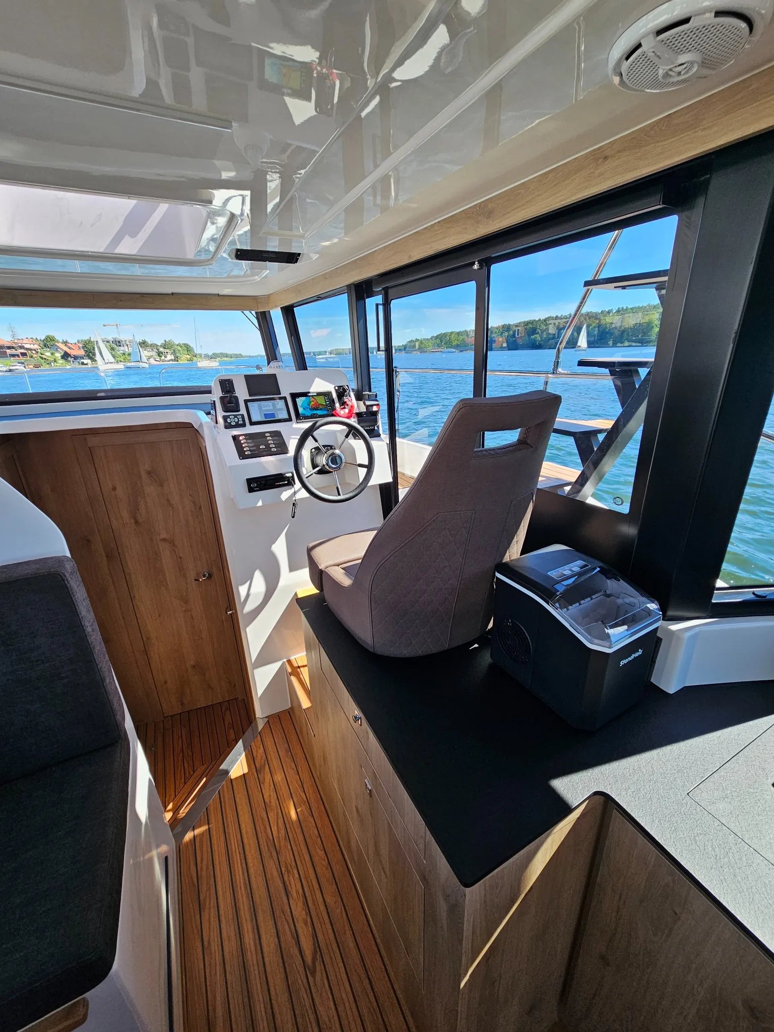 A white boat with a black top and a black chair.