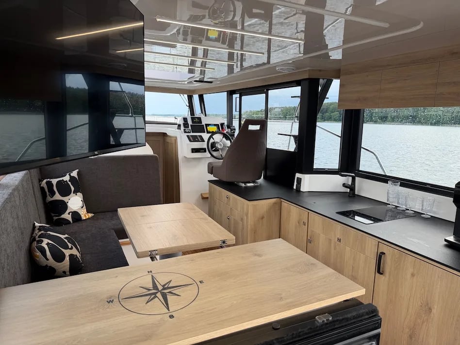 A boat with a wooden table and a compass on the table.