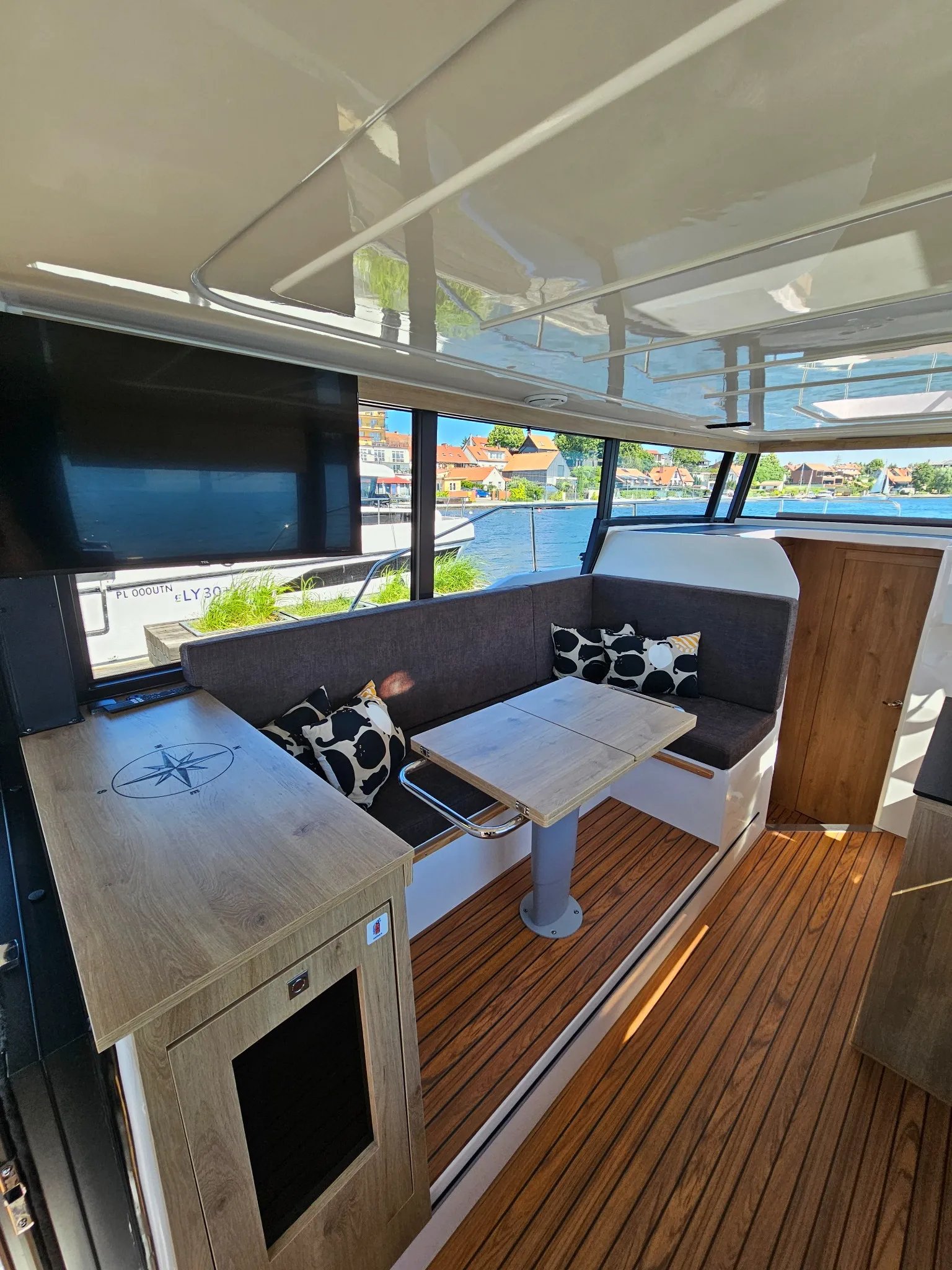 A boat with a wooden interior and a flat screen TV.