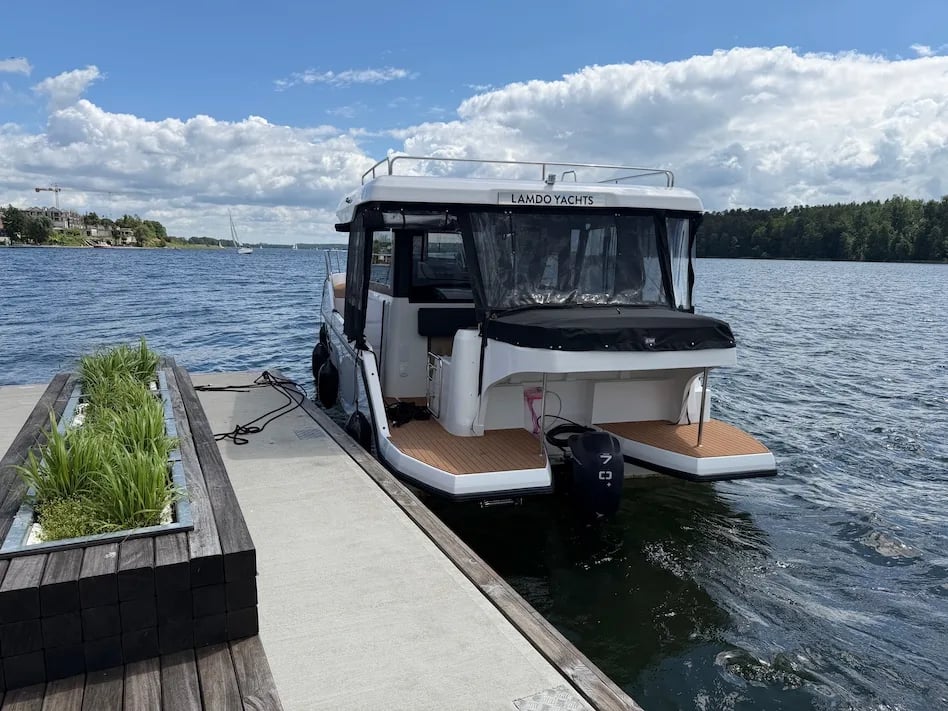 Stern view of the Lamdo eLY30+ showing the electric outboard and twin bathing platforms.