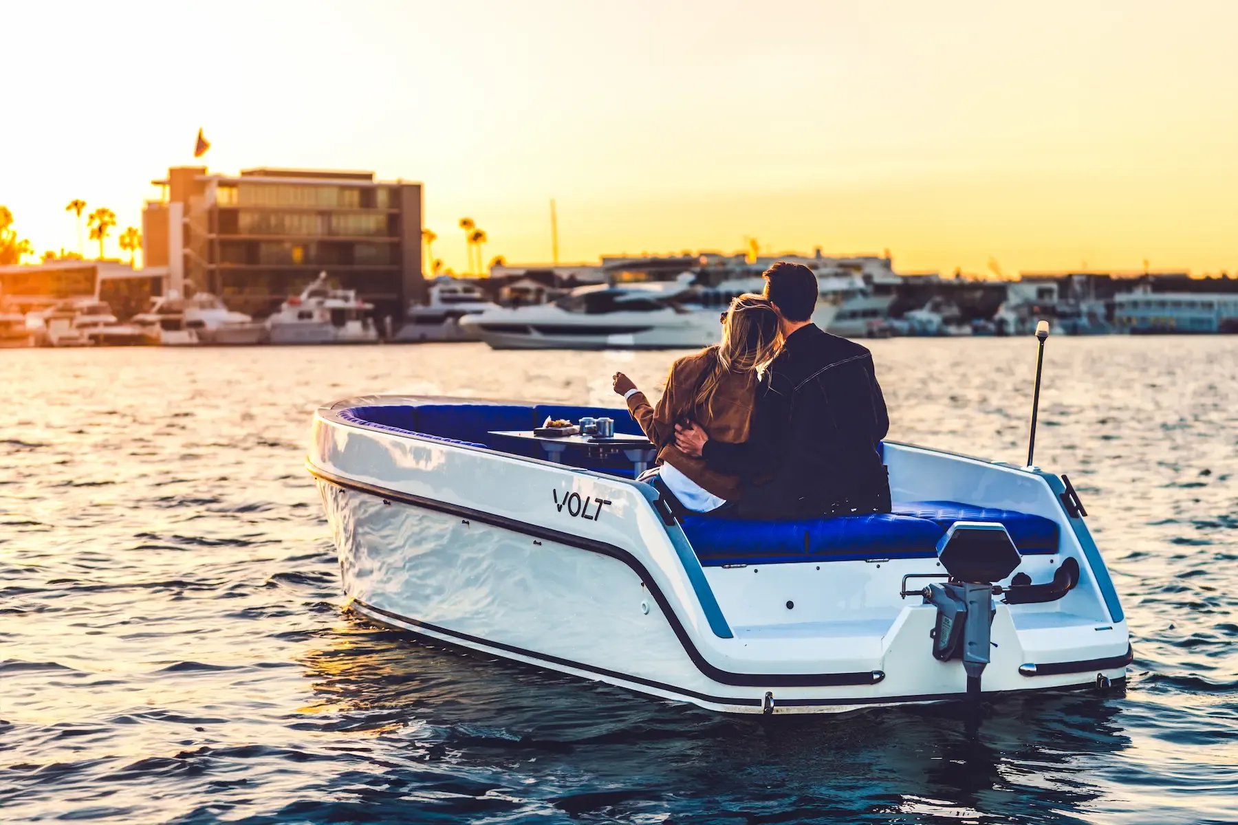 A blue and white boat with the name Volt on the side.