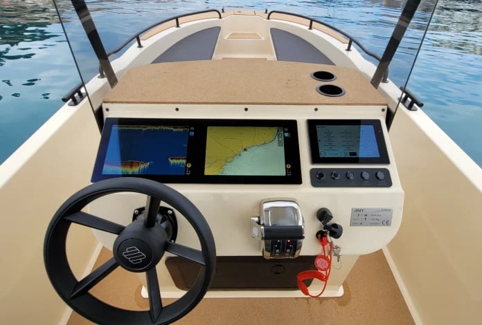 A boat with a black wheel and a red rope.