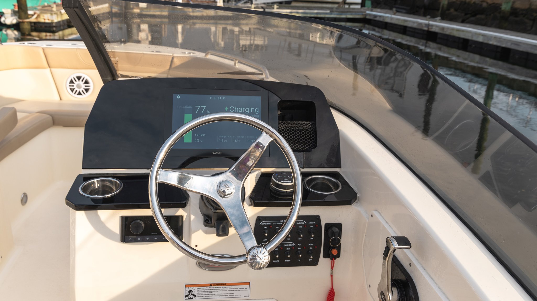 A boat with a black steering wheel and a digital display.