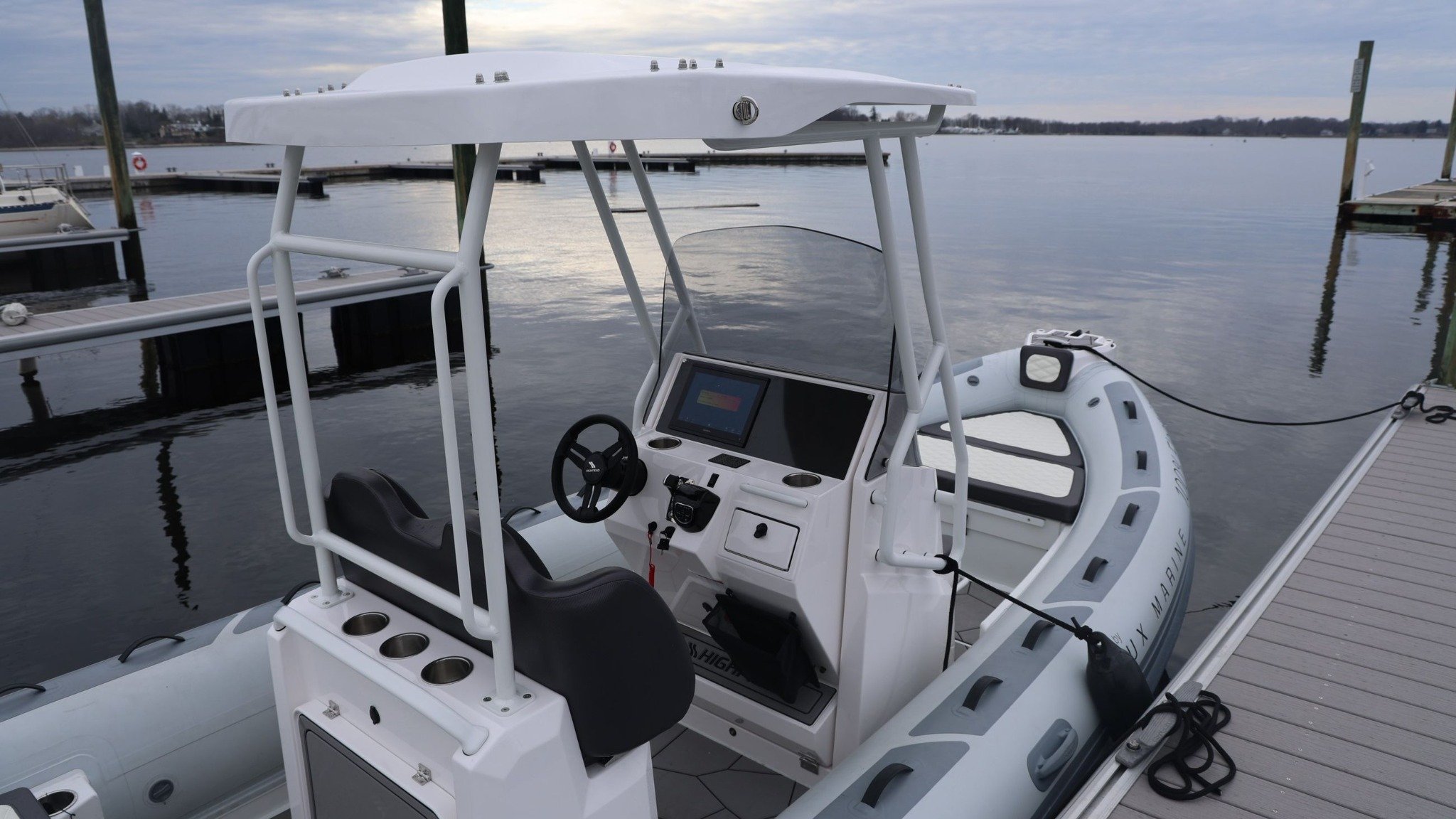 A white boat with a black steering wheel.