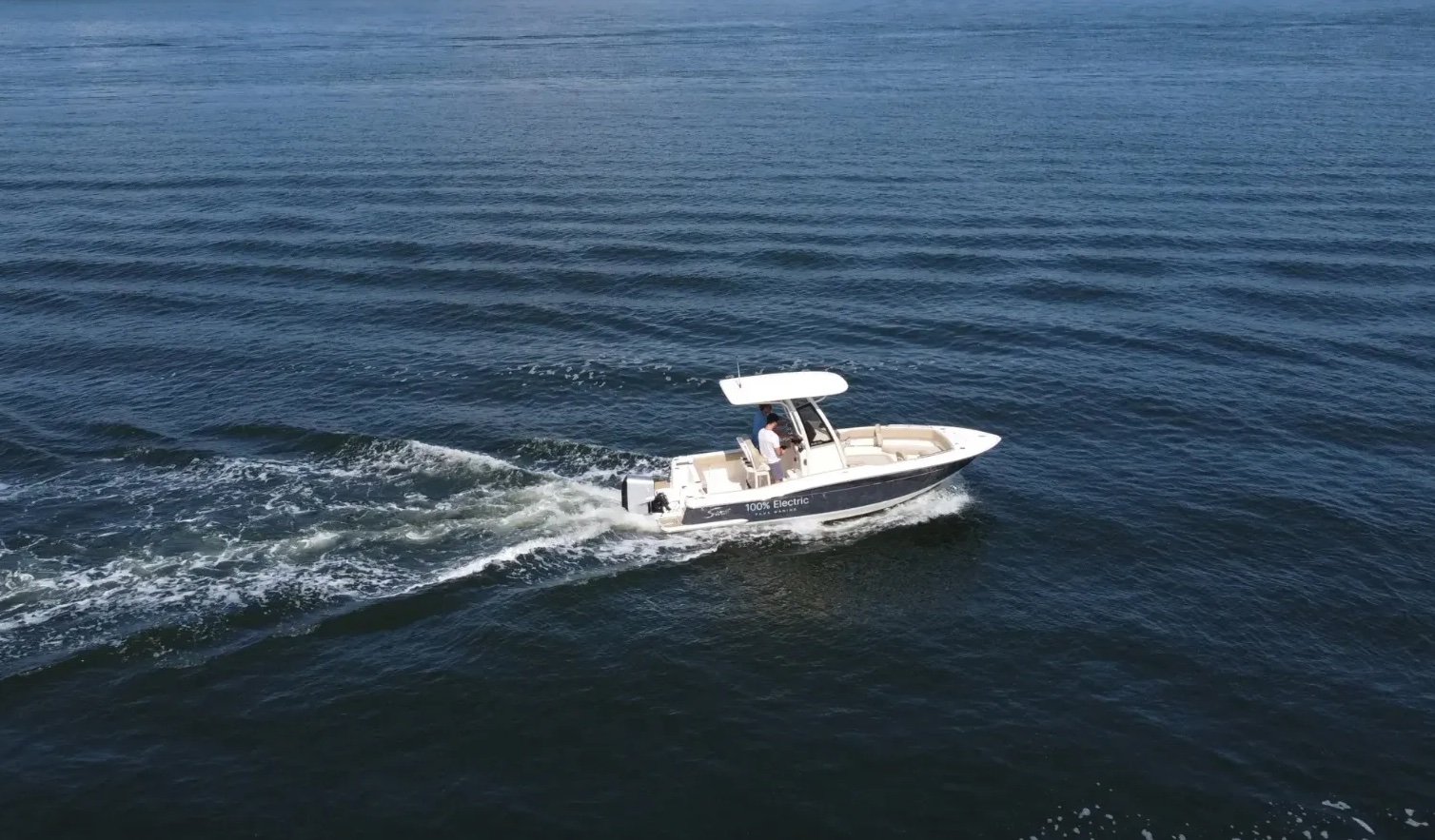 A small white boat with a man in the back.