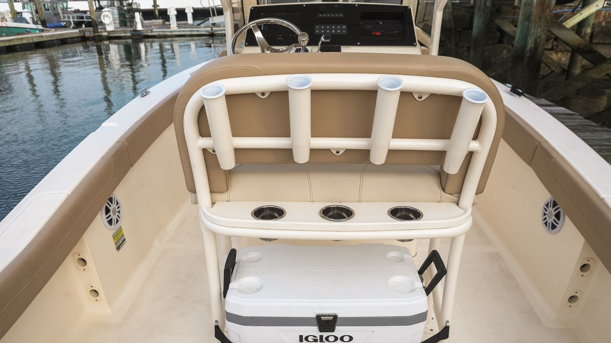 A boat with a white seat and a cooler.